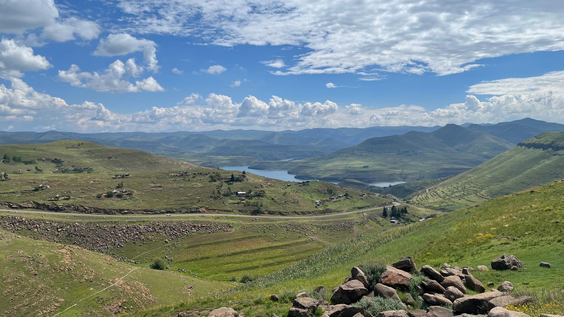 Ein weiter Blick über das Lesotho-Hochland, mit grünen Wiesen und Flüssen.