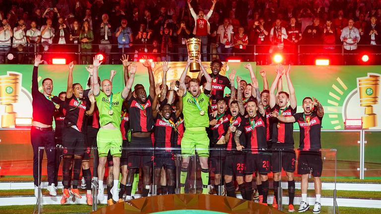 Bayer Leverkusens Spieler jubeln mit dem Pokal über das Double.