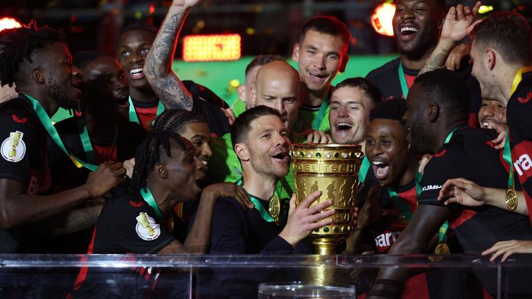 Leverkusens Trainer Xabi Alonso jubelt mit Pokal.