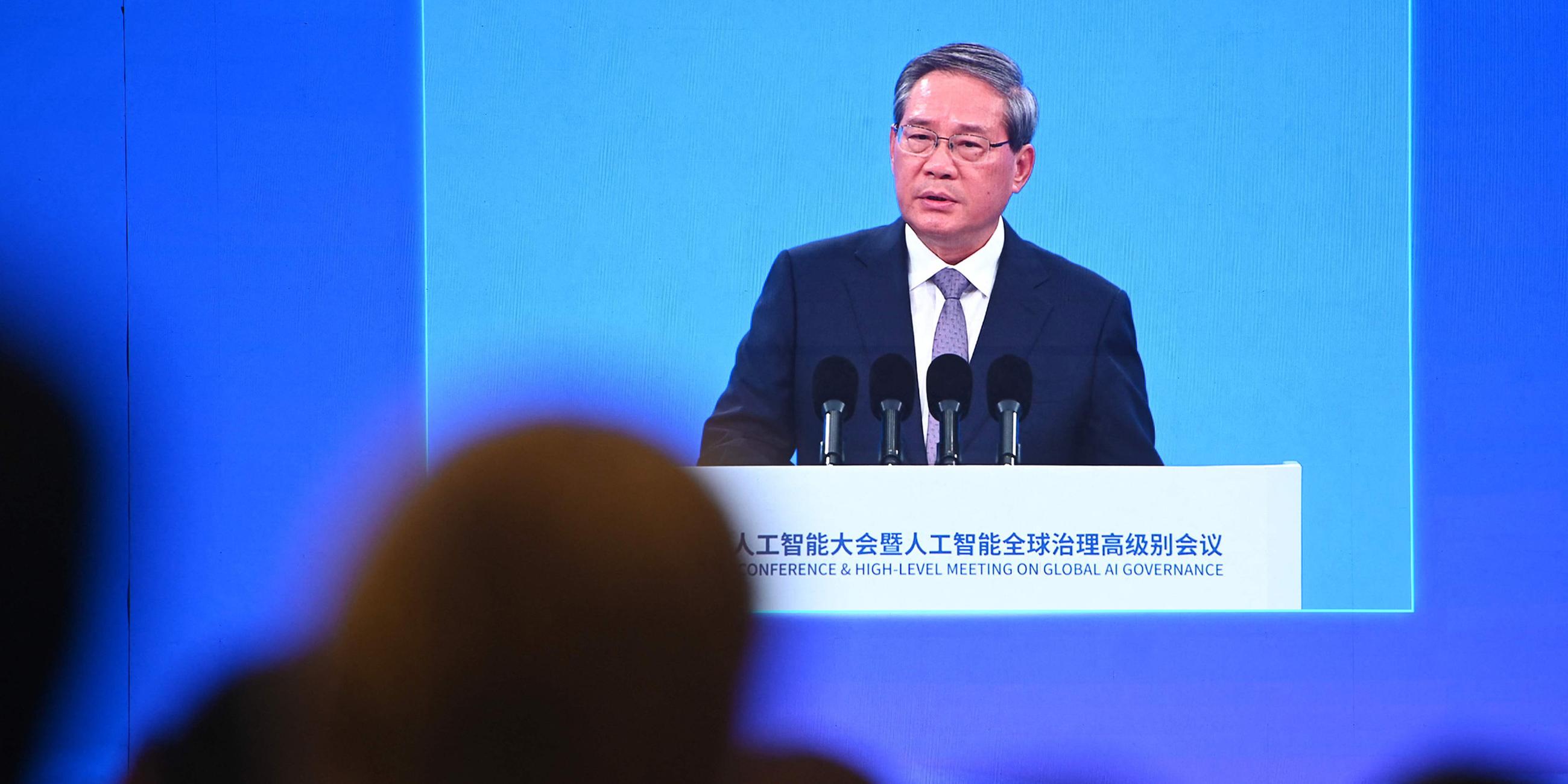 Der chinesische Premier Li Qiang ist auf einem Bildschirm zu sehen, während er am 26. Juli 2025 bei der Eröffnungszeremonie der Weltkonferenz für Künstliche Intelligenz in Shanghai spricht.