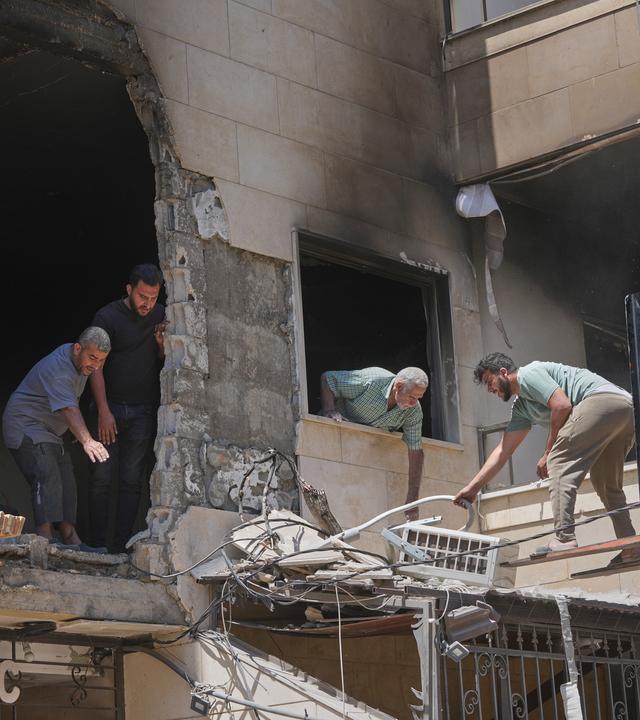 29.05.2026, Libanon, Beirut: Anwohner und Arbeiter räumen die Trümmer aus einem Wohnhaus, das am Vortag bei einem israelischen Luftangriff in Choueifat in Dahiyeh, einem südlichen Vorort von Beirut, beschädigt wurde.