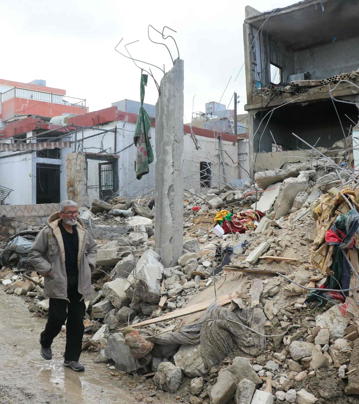Menschen laufen an einem zestörten Gebäude in Burj Rahal im Libanon vorbei.