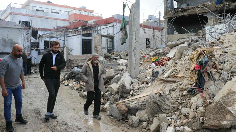 Menschen laufen an einem zestörten Gebäude in Burj Rahal im Libanon vorbei.