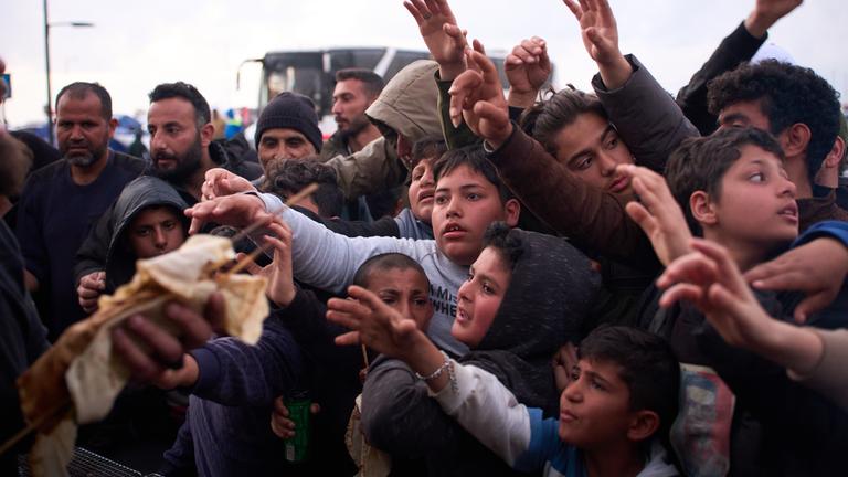 Vertriebene Kinder greifen nach gespendeten Lebensmitteln in der Nähe von Zelten, die ihnen als Unterschlupf dienen, nachdem sie vor dem israelischen Bombardement im Südlibanon geflohen sind. 