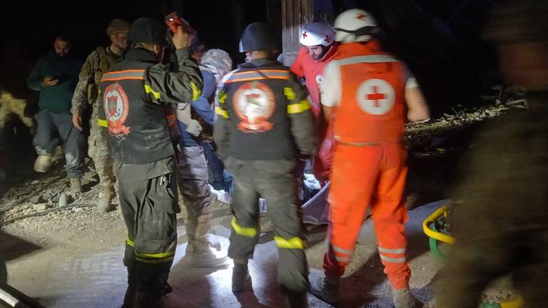 Dieses vom libanesischen Zivilschutz veröffentlichte Foto soll libanesische Freiwillige des Roten Kreuzes und Mitarbeiter des Zivilschutzes zeigen, die den Leichnam einer libanesischen Journalistin tragen, die für die Tageszeitung Al-Akhbar gearbeitet hat und bei einem israelischen Luftangriff getötet wurde. 