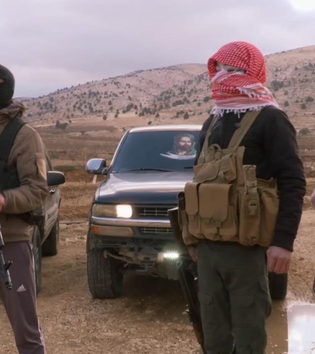 Vermummte Männer mit Waffen