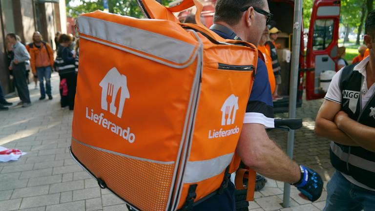 Mitarbeitende von Lieferando protestieren gegen eine geplante Auslagerung.