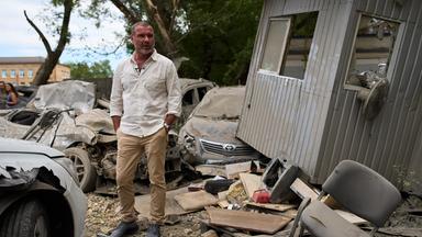 Auf dem Bild zu sehen ist: Schauspieler Liev Schreiber in einer Halbtotalen umgeben von Trümern des russichen Angriff Krieges.
