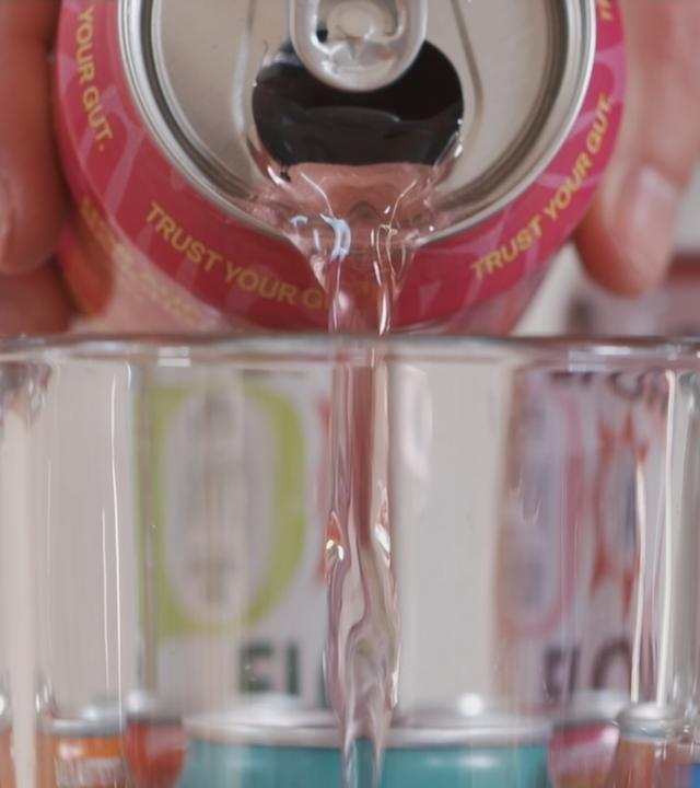 Eine Limo wird in ein Glas gegossen.