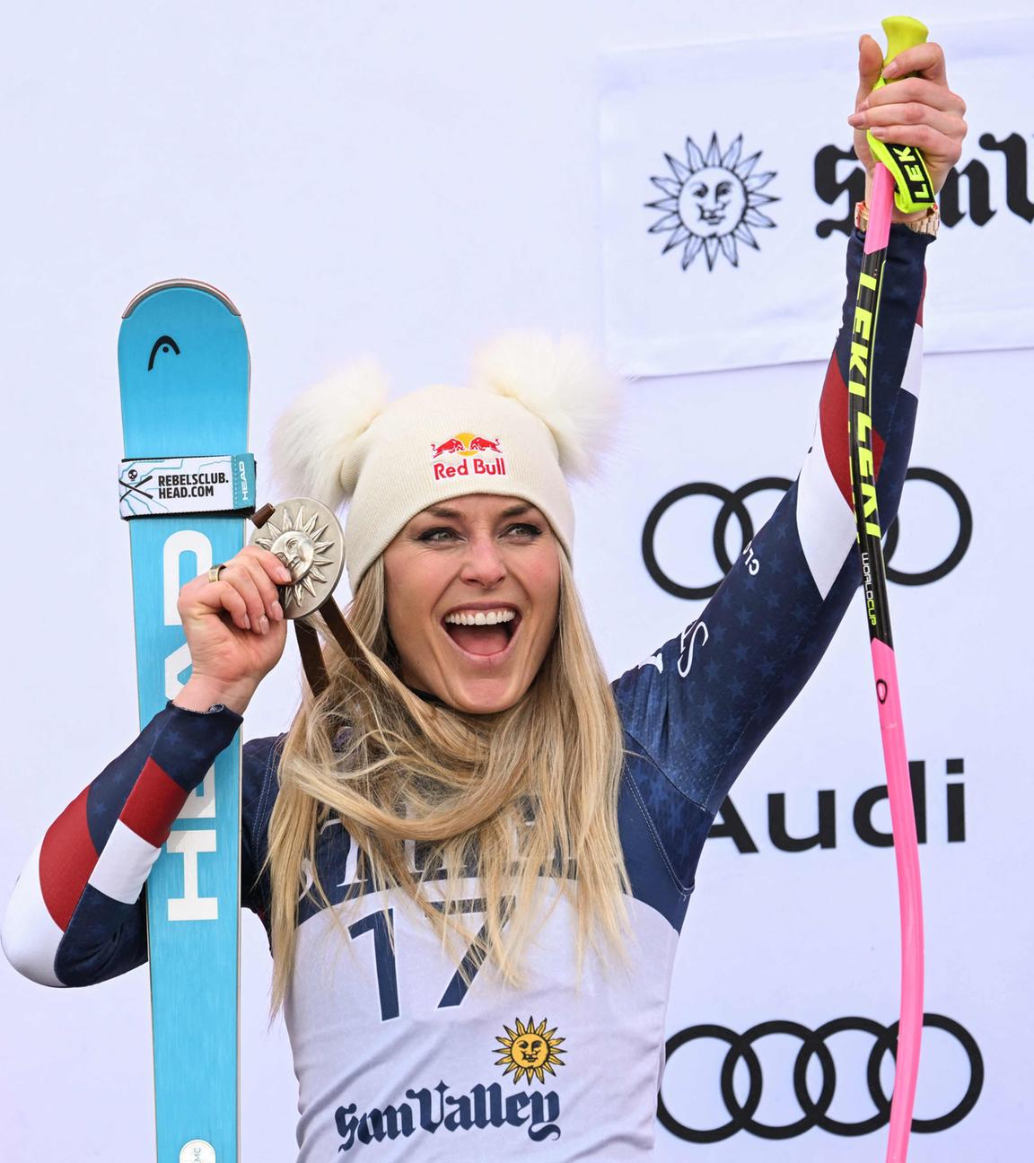 Lindsey Vonn jubelt mit ihren Skiern, Skistöcken und einer Silbermedaille.
