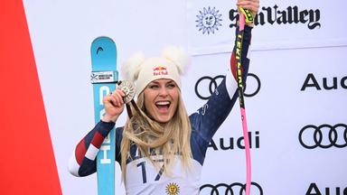 Lindsey Vonn jubelt mit ihren Skiern, Skistöcken und einer Silbermedaille.