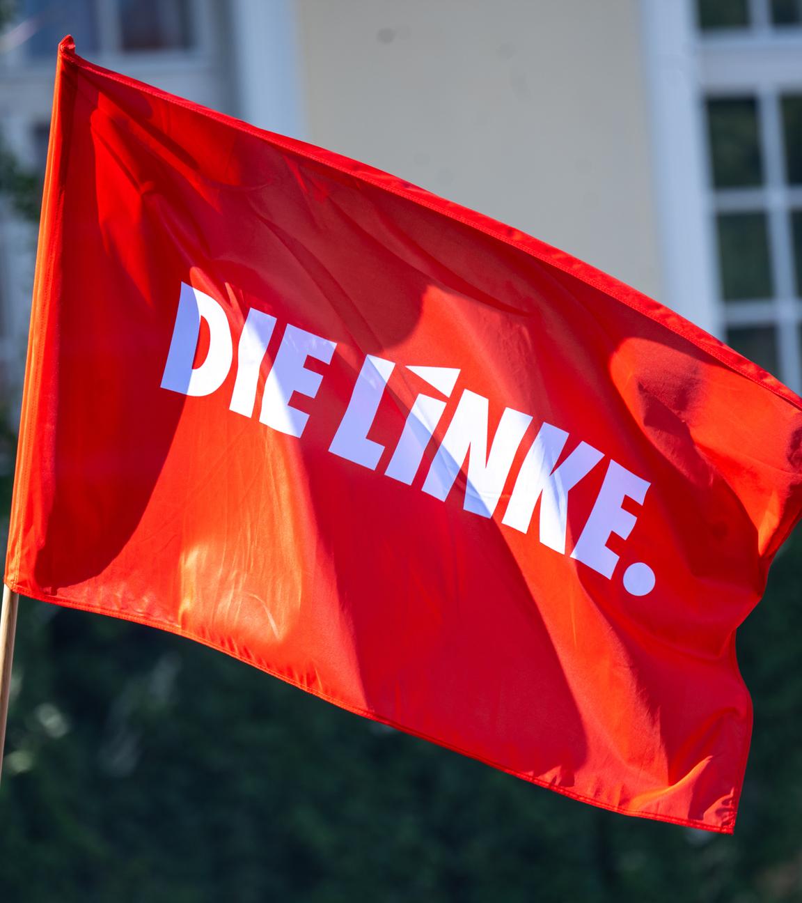 Eine Fahne mit dem Logo der Partei Die Linke weht im Wind bei einer Wahlkampfveranstaltung der Partei vor der Europawahl am Brandenburger Tor