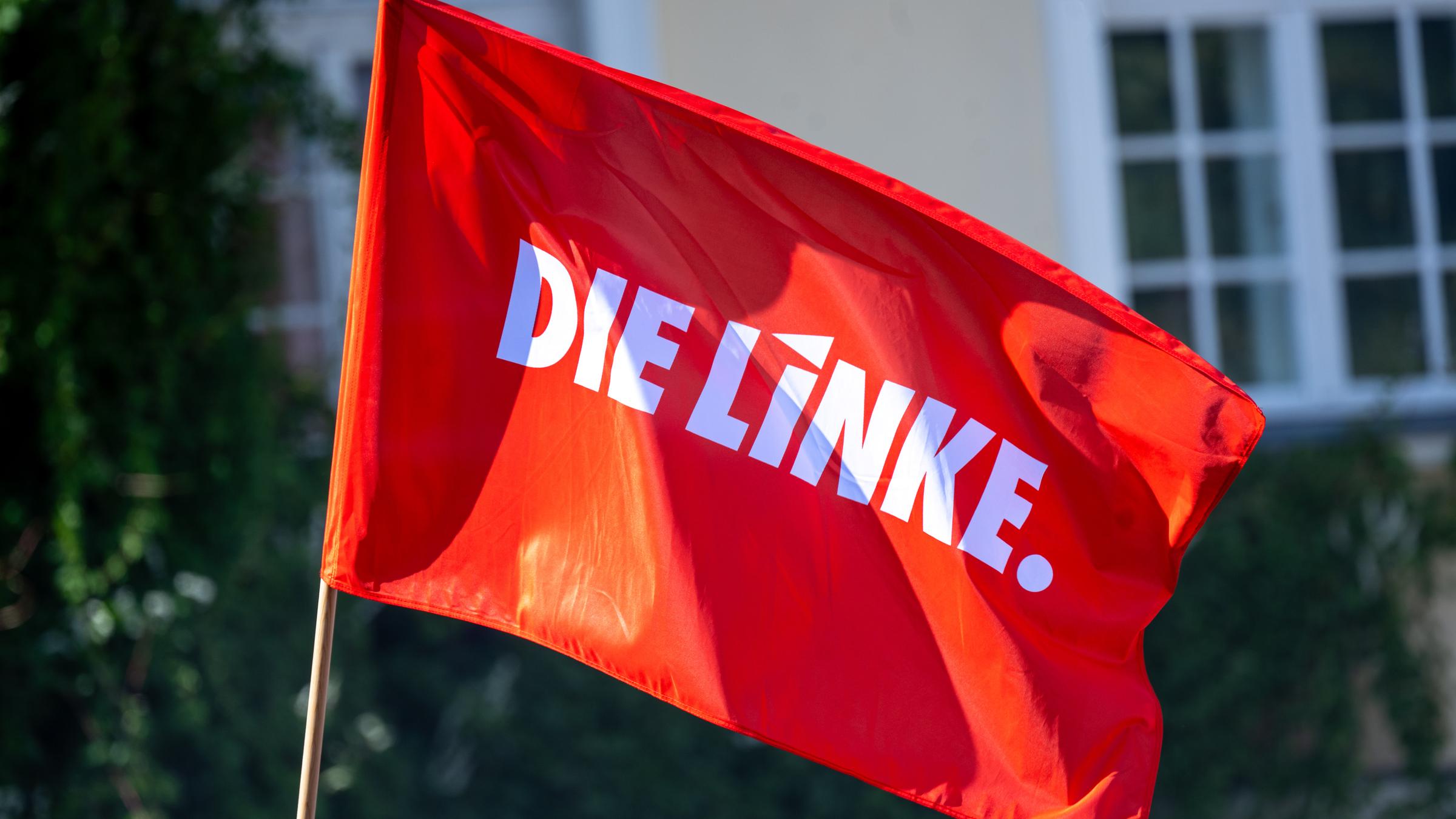 Eine Fahne mit dem Logo der Partei Die Linke weht im Wind bei einer Wahlkampfveranstaltung der Partei vor der Europawahl am Brandenburger Tor