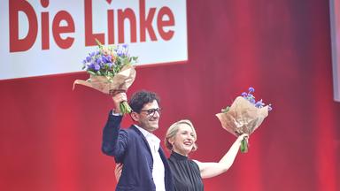 Luigi Pantisano und Ines Schwerdtner mit Blumen in den Händen auf der Parteitagsbühne.