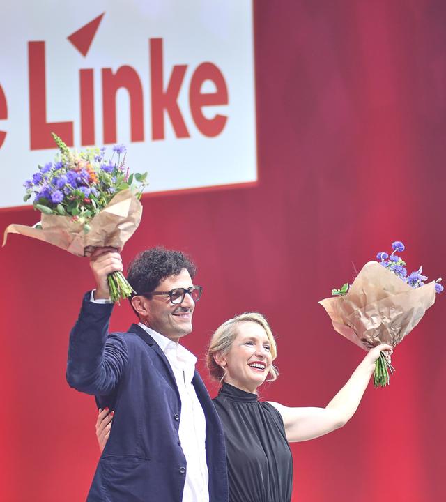 Luigi Pantisano und Ines Schwerdtner mit Blumen in den Händen auf der Parteitagsbühne.