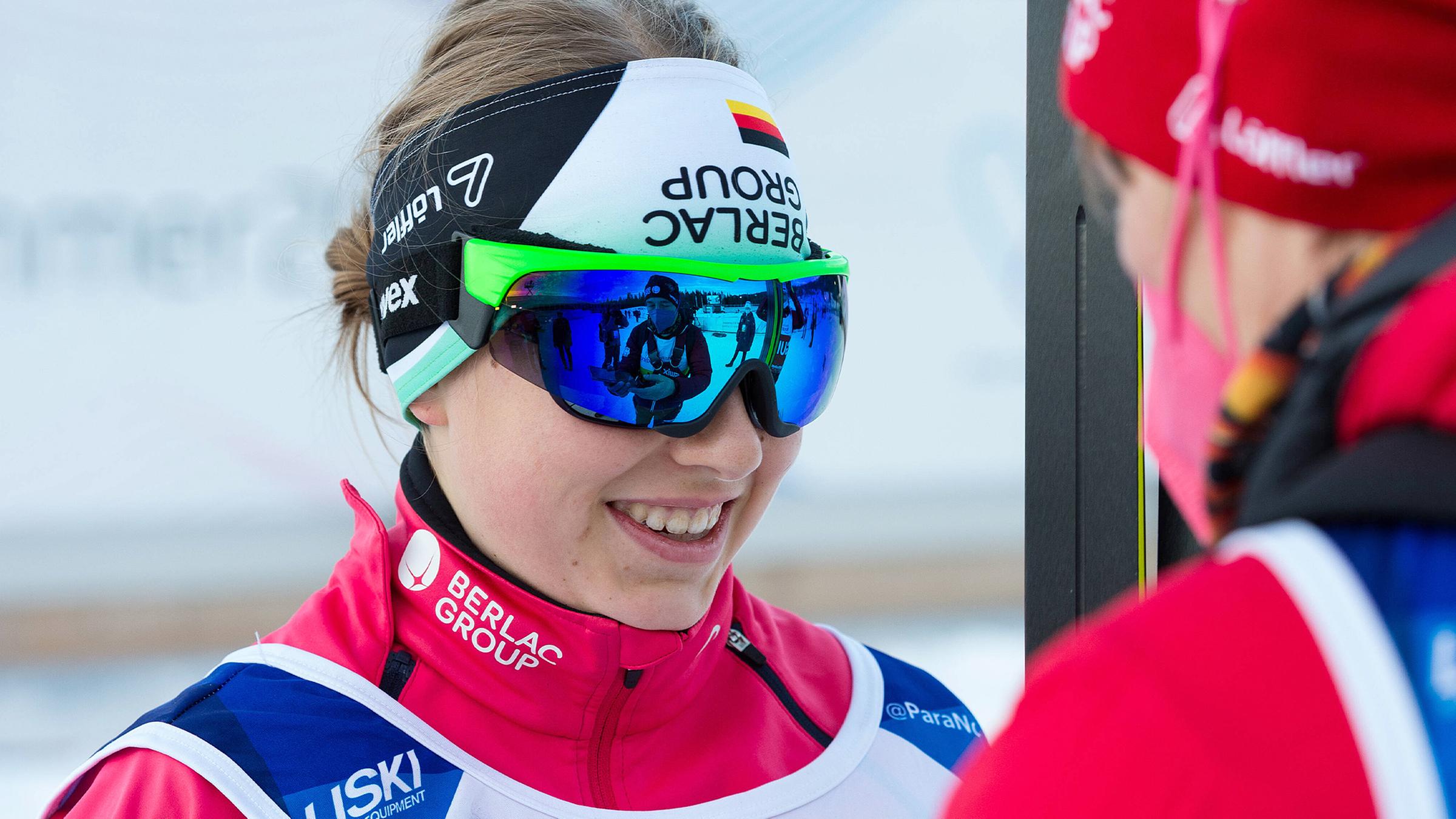 Linn Kazmaier trägt eine große Sonnenbrille und lächelt.