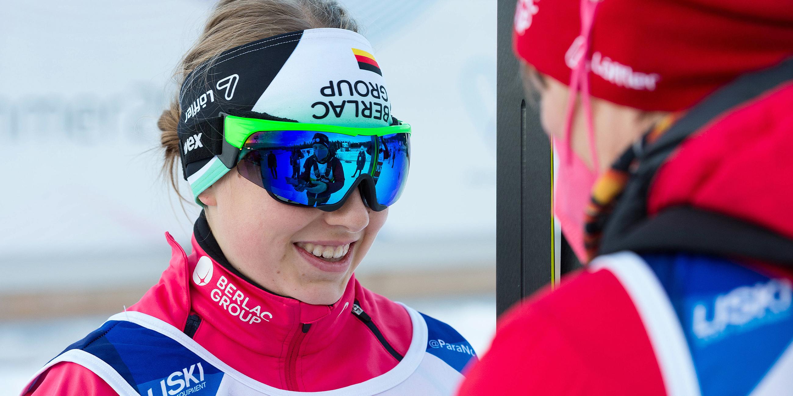 Linn Kazmaier trägt eine große Sonnenbrille und lächelt.