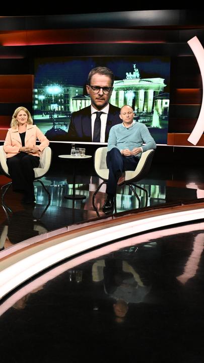 Carsten Linnemann ist bei Lanz im Anzug auf einem Bildschirm zu sehen. Im Vordergrund sitzen weitere Gäste von Markus Lanz.