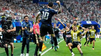 Der argentinische Nationalspieler Lionel Messi springt jubelnd in die Luft, während seine Teamkollegen jubelnd auf ihn zurennen
