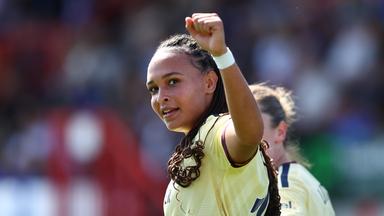 Die 19-jährige deutsche Fußballerin Lisa Baum blickt über die linke Schulter zurück in die Kamera. Sie hat die linke Faust zu einer Jubelpose erhoben.