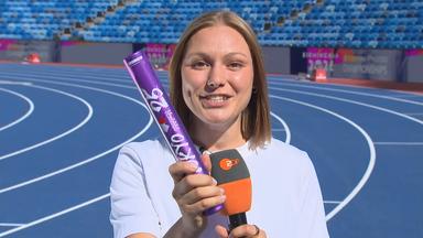 Die ehemalige deutsche Leichtathletin Lisa Mayer hält den Stab, der beim Staffellauf genutzt wird, in die Kamera