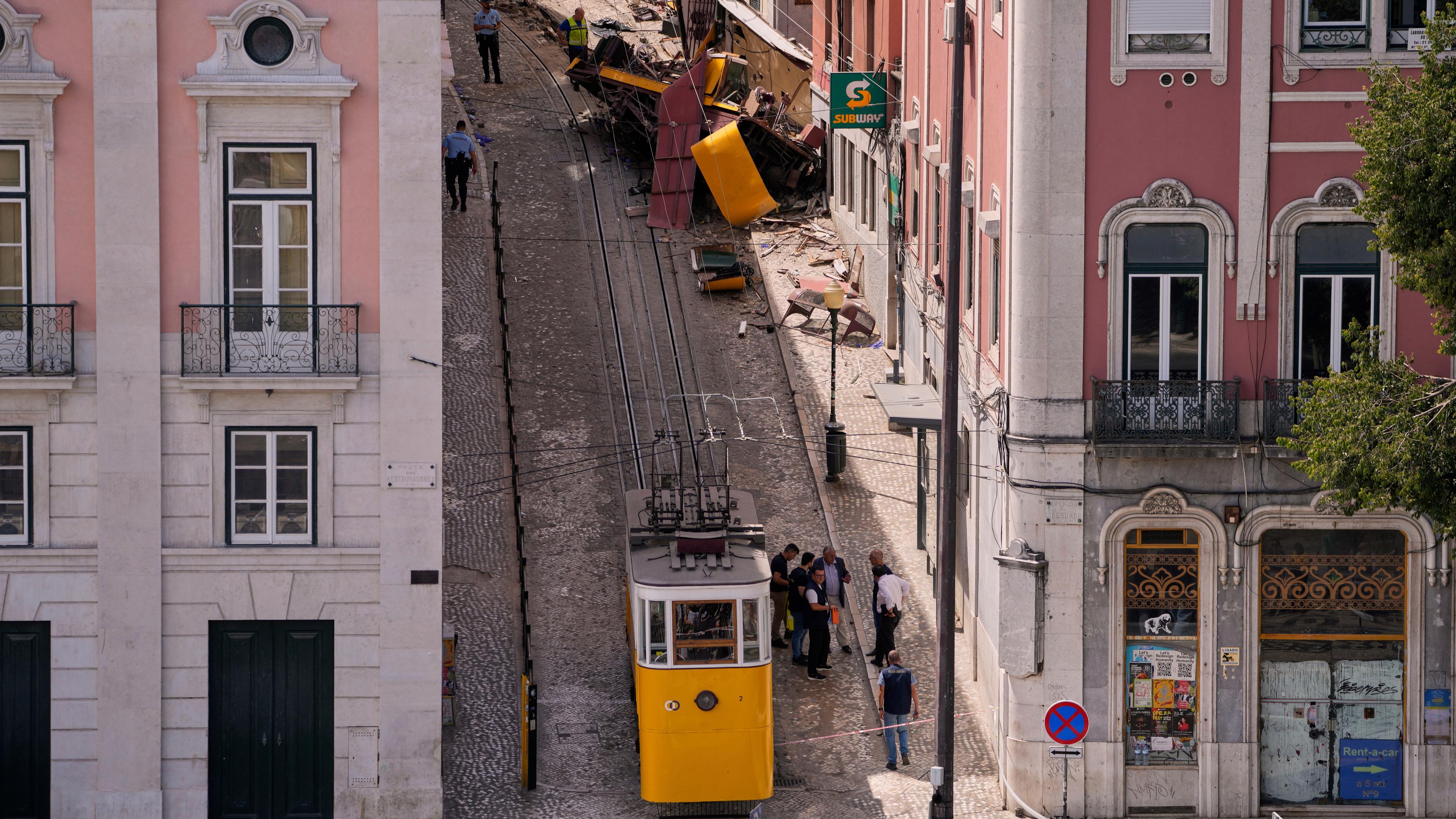 Polizisten untersuchen am Donnerstag, den 4. September 2025, in Lissabon, Portugal, die Stelle, an der eine Touristenstraßenbahn entgleist und verunglückt ist.