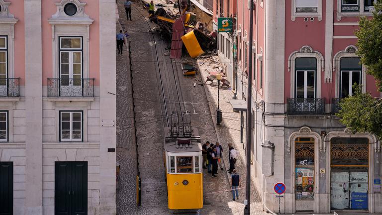 Polizisten untersuchen am Donnerstag, den 4. September 2025, in Lissabon, Portugal, die Stelle, an der eine Touristenstraßenbahn entgleist und verunglückt ist.