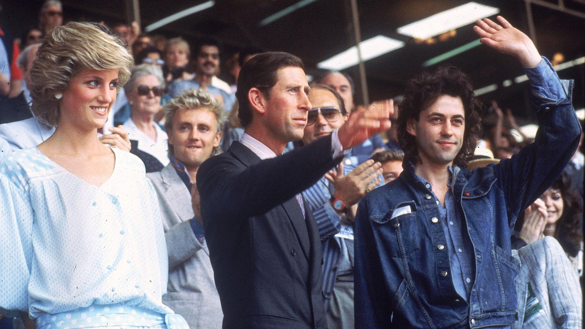 Prinzessin Diana und der damalige Prinz Charles stehen neben "Live Aid"-Gründer Bob Geldorf im Wembley Stadium in London.