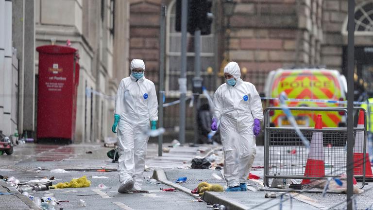 Forensic officers examine the site where a 53-year-old British man plowed a minivan into a crowd of Liverpool soccer fans who were celebrating the city's Premier League championship Monday, injuring more than 45 people in Liverpool, England, Tuesday, May 27, 2025.