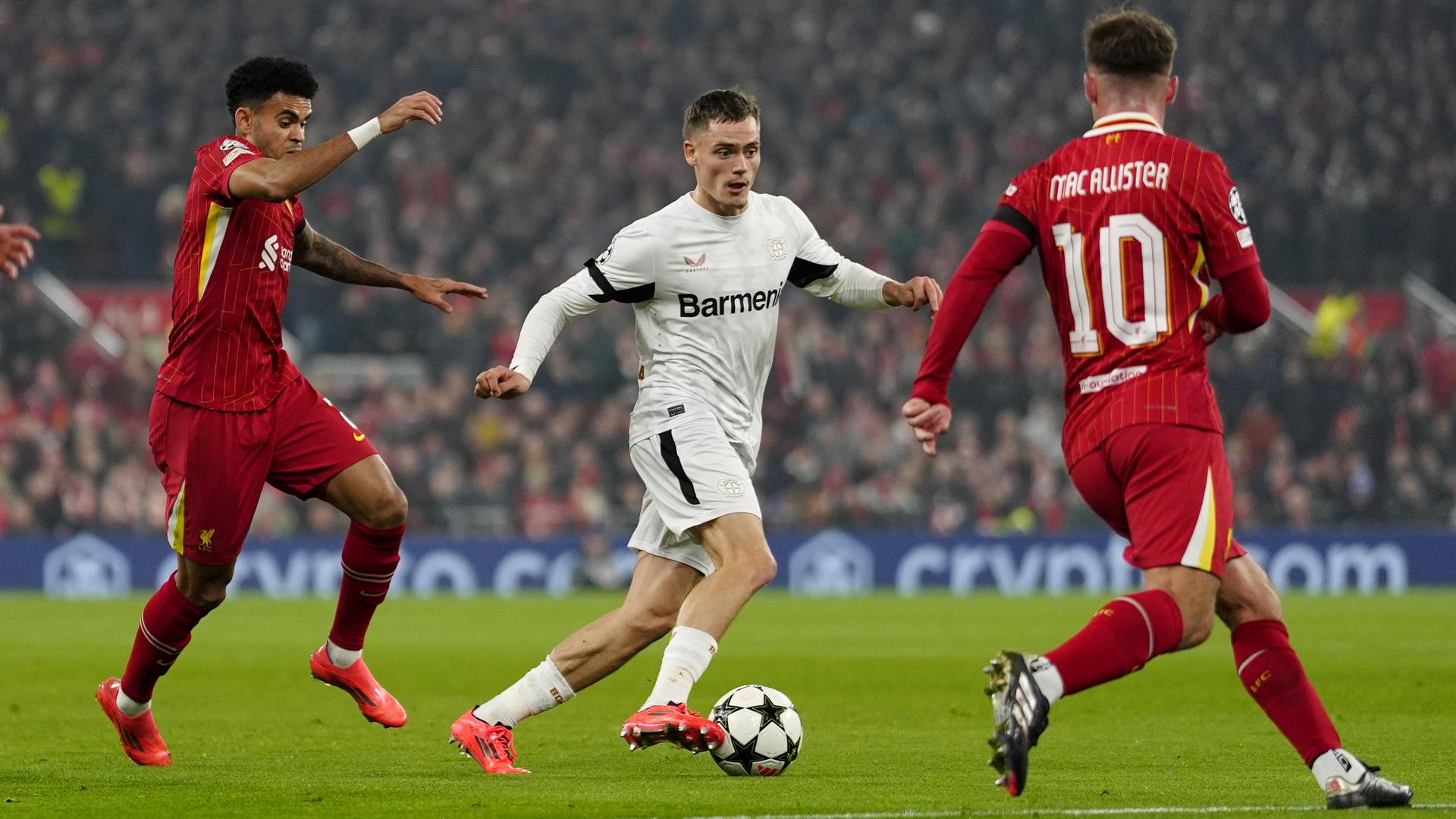 Champions League: Leverkusens Florian Wirtz (M) und Liverpools Luis Diaz (l) kämpfen um den Ball