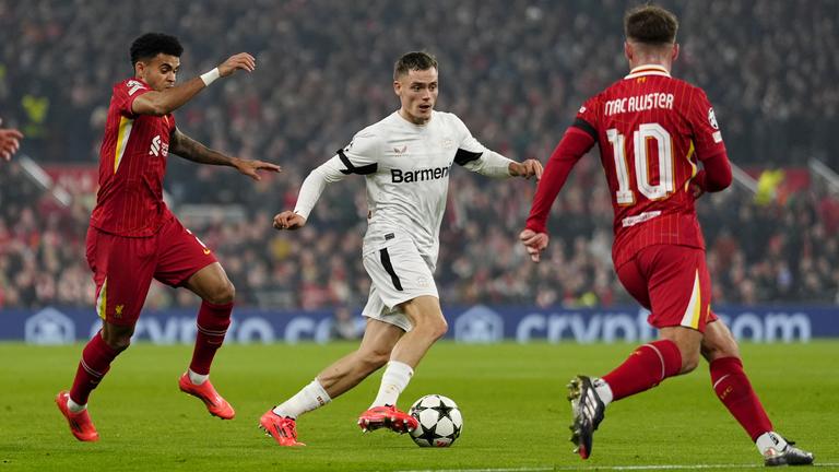 Champions League: Leverkusens Florian Wirtz (M) und Liverpools Luis Diaz (l) kämpfen um den Ball