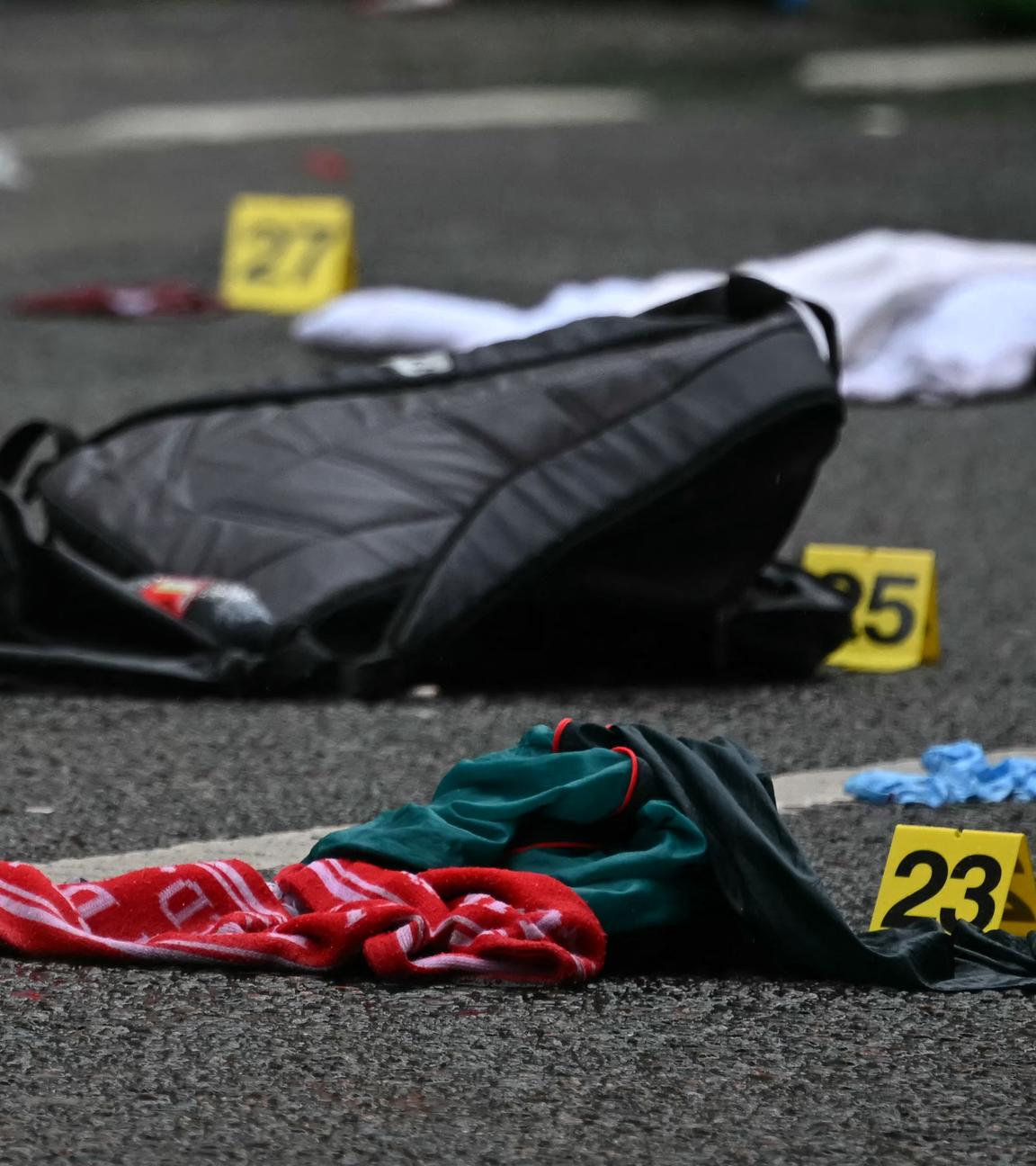 Police forensics identification numbers are pictured among discarded belongings at the scene on Water Street in Liverpool, north-west England on May 27, 2025, where a car on May 26 ploughed in to crowds that had gathered to watch an open-top bus victory parade for Liverpool's Premier League trophy parade. 