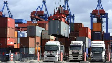 Drei LKW werrden mit Containern beladen.
