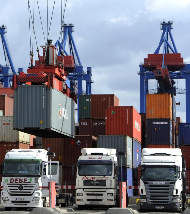 Drei LKW werrden mit Containern beladen.