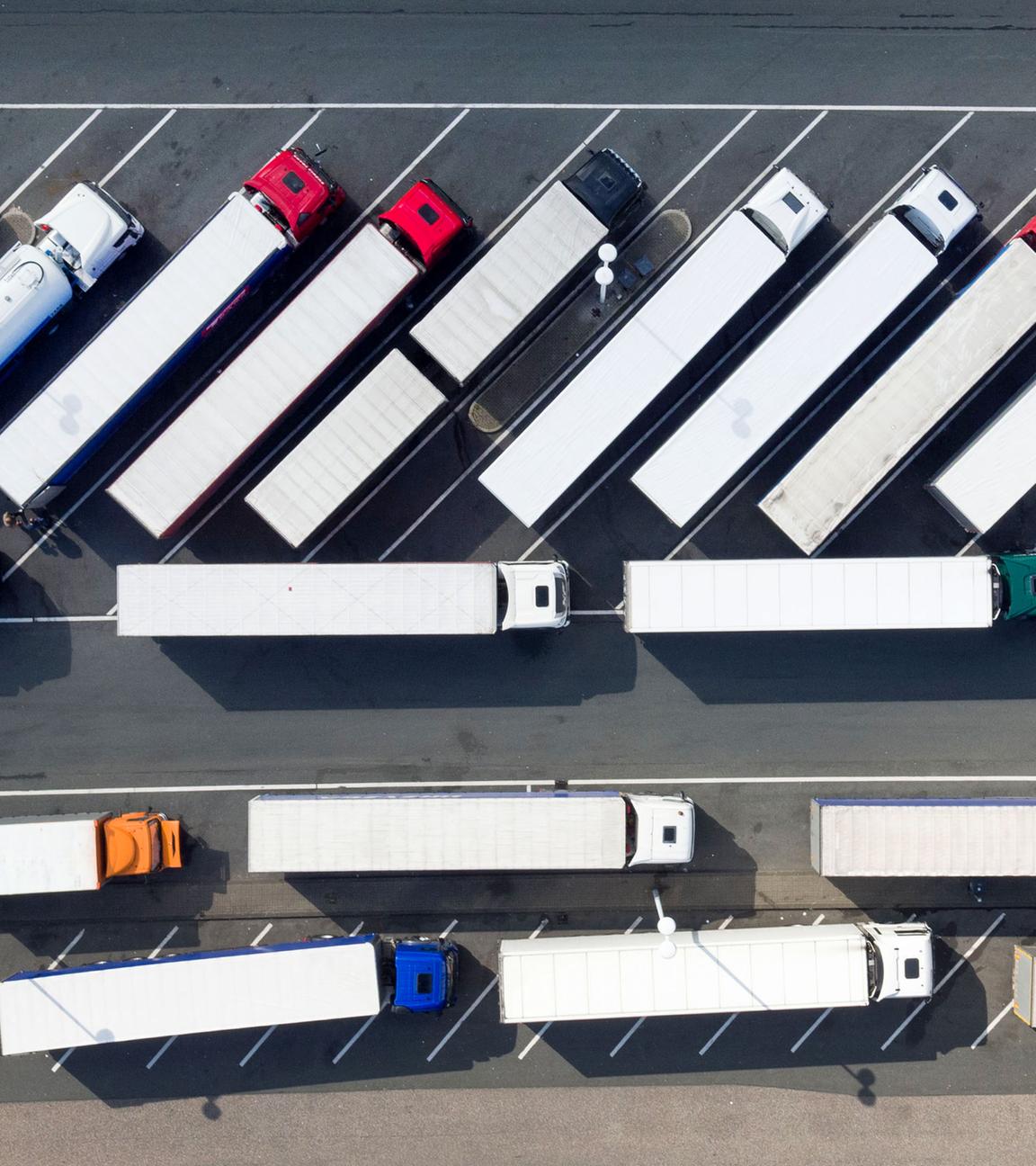 Luftaufnahme, zahlreiche LKW parken auf dem Gebiet einer Autobahn-Raststätte.