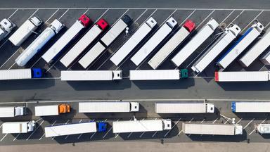 Luftaufnahme, zahlreiche LKW parken auf dem Gebiet einer Autobahn-Raststätte.