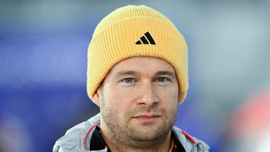 Der deutsche Bob-Pilot Johannes Lochner mit gelber Mütze und ernstem Blick