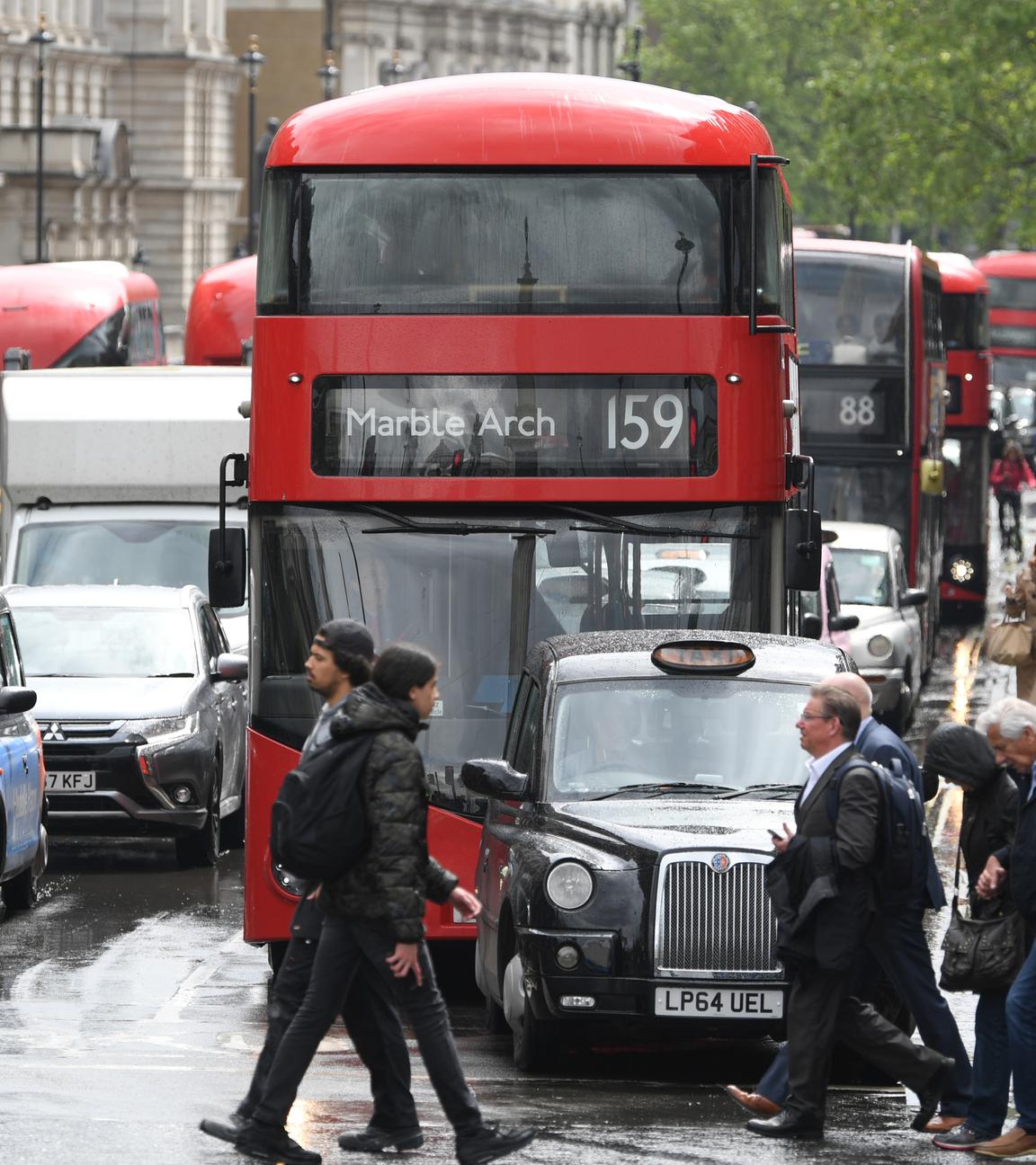 Fußgänger laufen über eine vielbefahrene Straße in London.