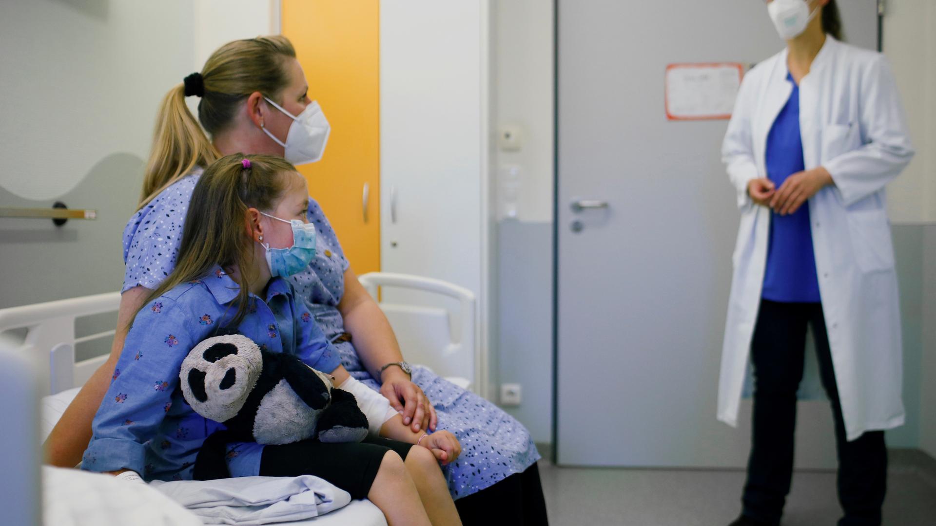 Ein Mädchen, das an Long Covid erkrankt ist, und seine Mutter sprechen mit einer Ärztin