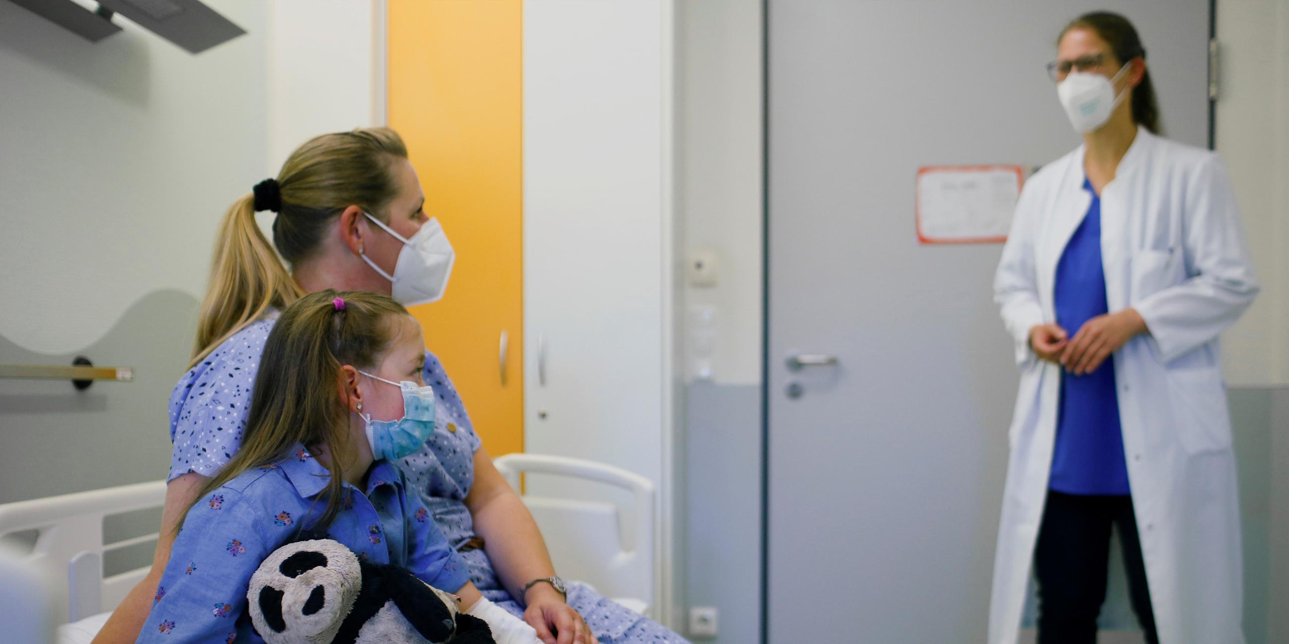 Ein Mädchen, das an Long Covid erkrankt ist, und seine Mutter sprechen mit einer Ärztin