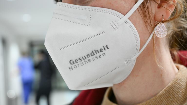 Eine Frau trägt im Klinikum Kassel einen Mund-Nasen-Schutz mit dem Schriftzug "Gesundheit Nordhessen".