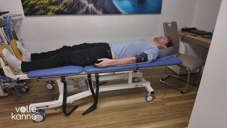 Mann liegt auf einer Liege in einem Untersuchungsraum.