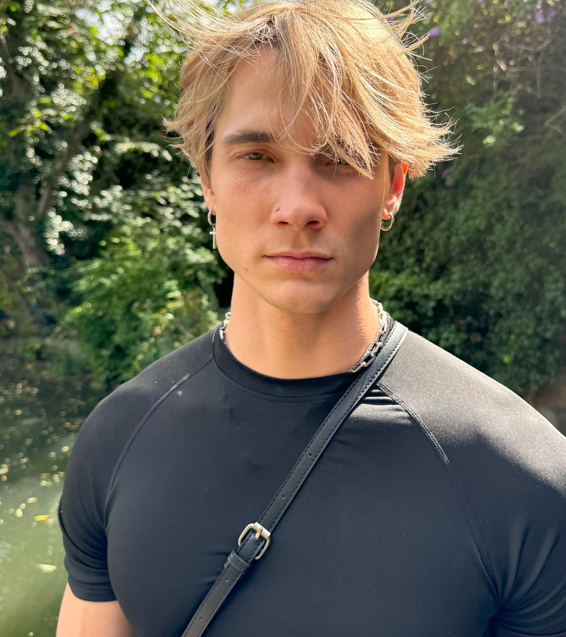 Portraitaufnahme: Austin Wayne steht vor einem See und schaut in die Kamera. Er hat blonde Haare und eine ausgeprägte Kiefermuskulatur.