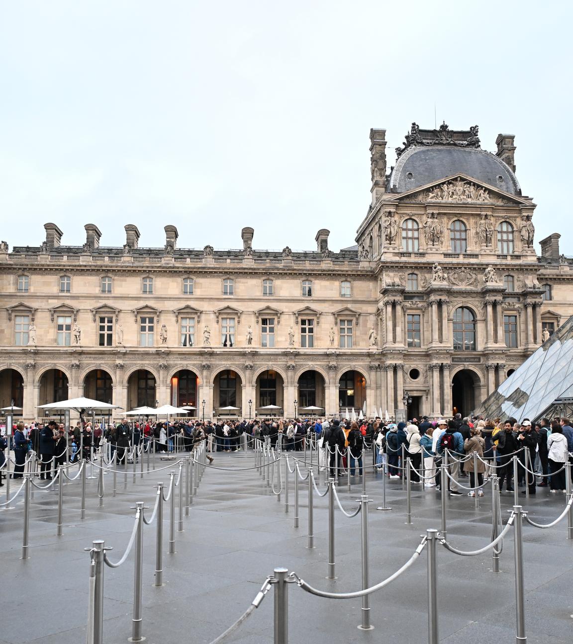 Menschen stehen Schlange, um das Louvre-Museum zu betreten, das nach dem Juwelenraub vom Sonntag (19.10.2025) für den Tag geschlossen bleibt.