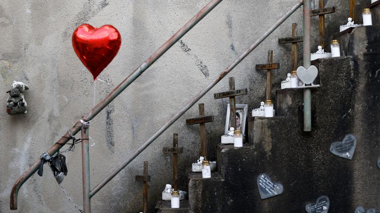 Treppe auf damaligem Loveparade-Gelände mit kleinen Holzkreuzen und einem roten Herz-Luftballon.
