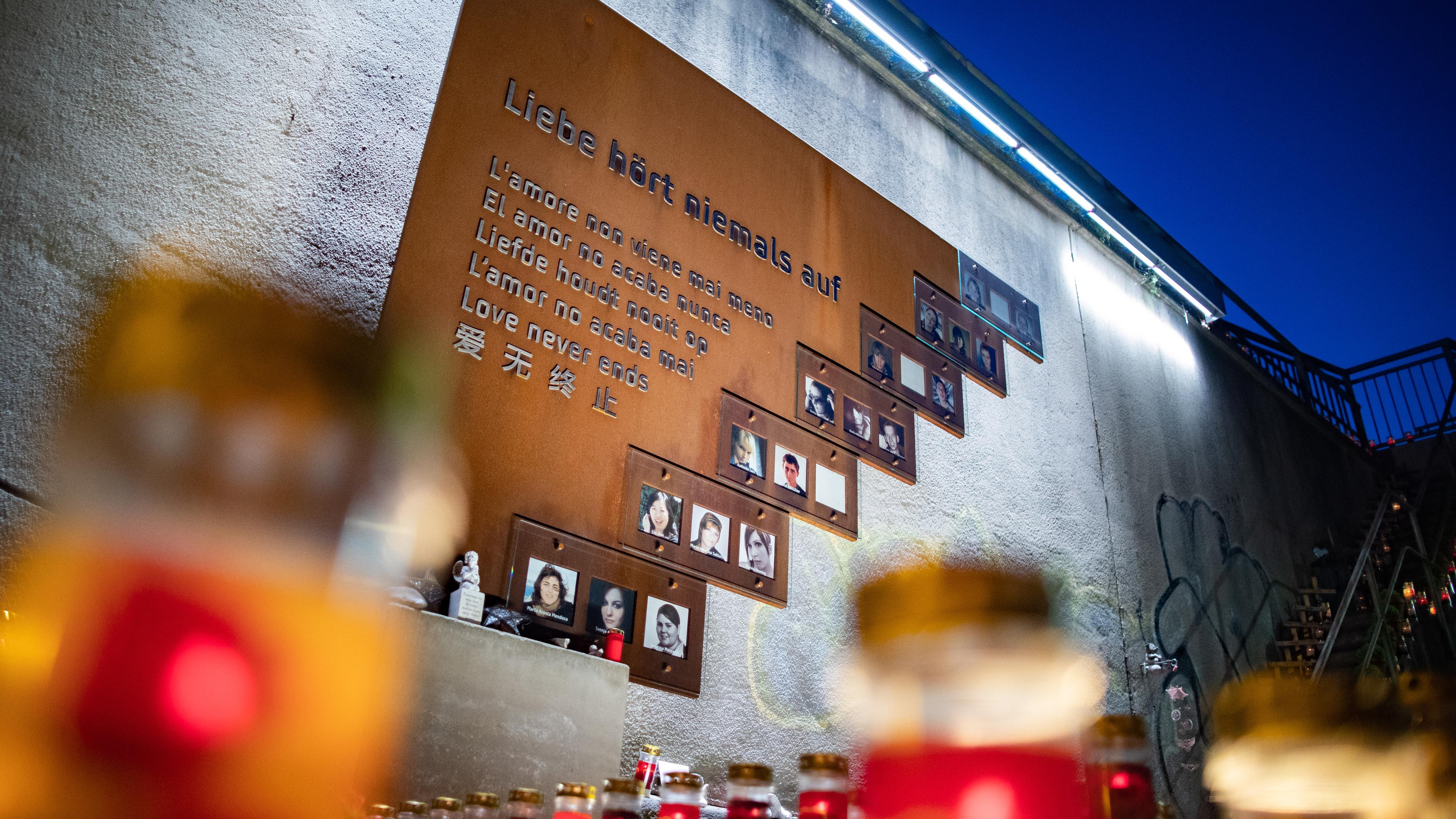 Brennende Kerzen und eine Gedenktafel an der Unglücksstelle der Loveparade 2010.
