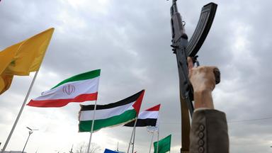 Ein Houthi-Anhänger hält eine Waffe in die Höhe, während andere bei einem Protest gegen Saudi-Arabien in Sanaa, Jemen, am 18. September 2026 Flaggen der vom Iran angeführten „Achse des Widerstands“ schwenken.
