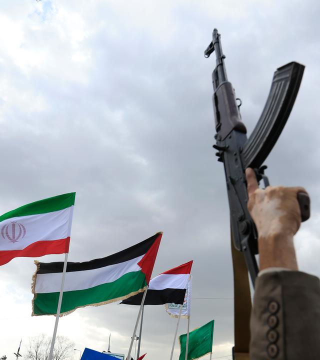 Ein Houthi-Anhänger hält eine Waffe in die Höhe, während andere bei einem Protest gegen Saudi-Arabien in Sanaa, Jemen, am 18. September 2026 Flaggen der vom Iran angeführten „Achse des Widerstands“ schwenken.