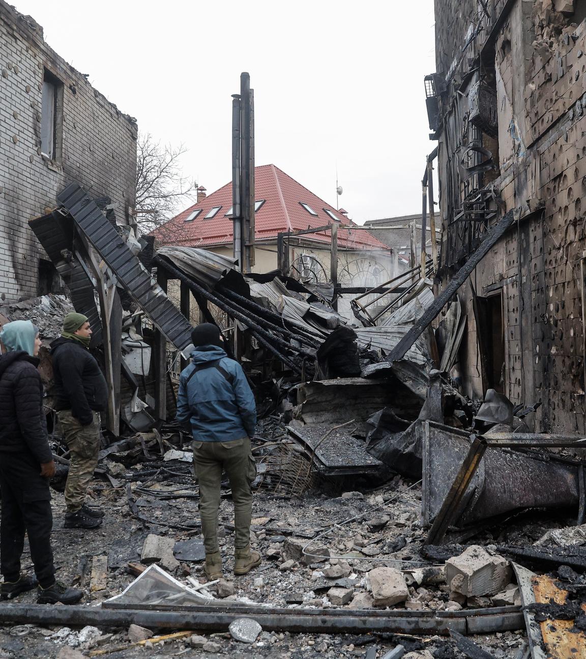 Beschädigtes Wohngebäude in Kiew nach russischem Angriff, Anwohner begutachten die Schäden.