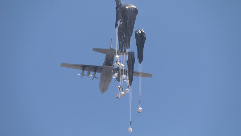 An airplane drops humanitarian aid over Gaza as seen from northern Gaza Strip.
